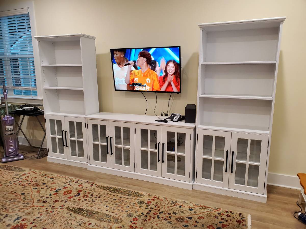Assembled white entertainment center with wall-mounted television